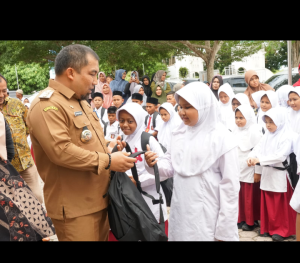 Pj Bupati Aceh Besar Serahkan 229 Paket Bantuan Yayasan Baitul Mal BRILiaN untuk Siswa Kurang Mampu